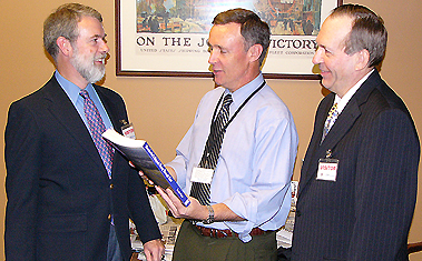 NH Union Leader/Sunday News publisher Joe McQuaid gets the first copy of the new Manchester Airport book from co-authors Ed Brouder (l) and Moe Quirin (r).